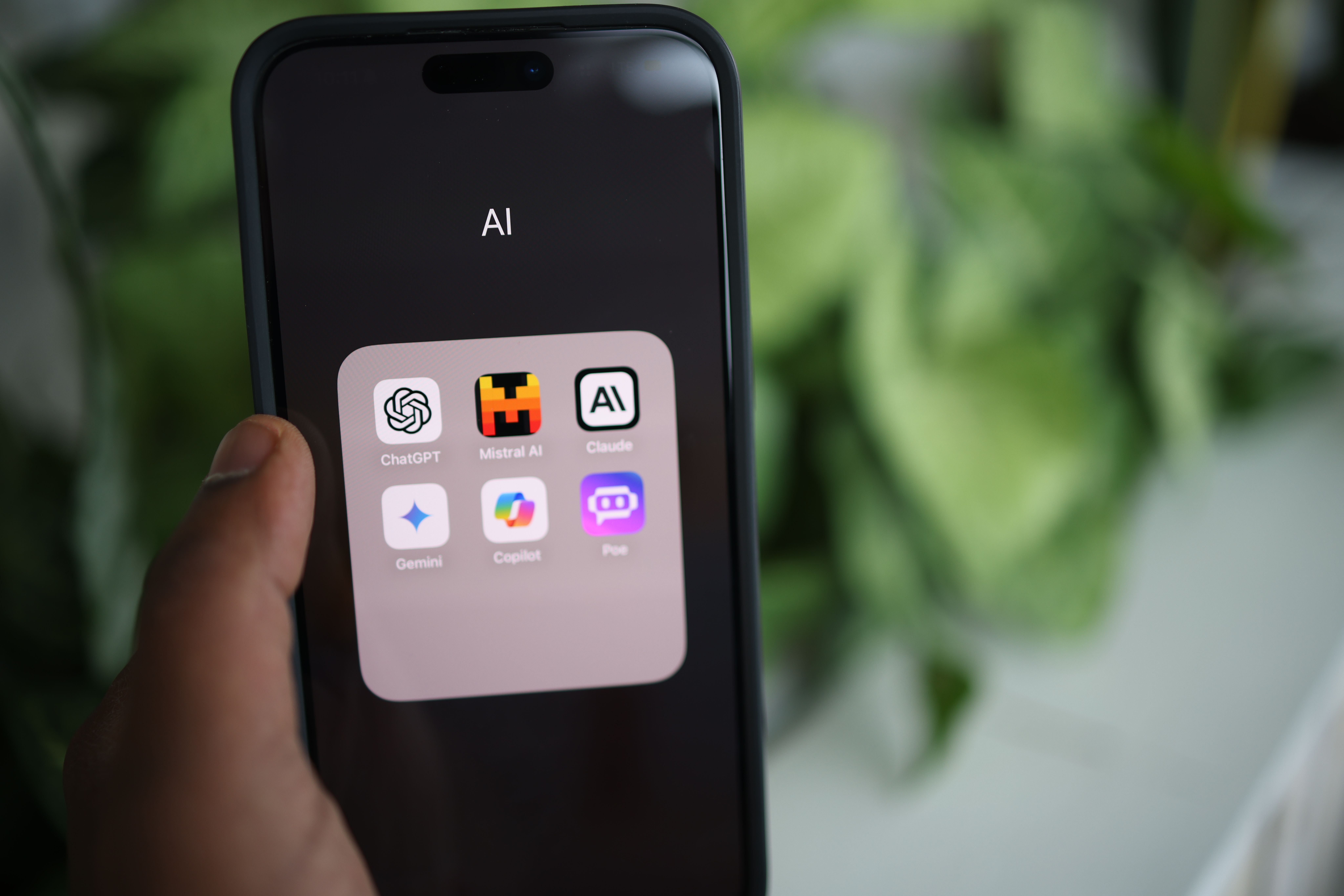 Smartphone showing a folder of AI apps including ChatGPT and Claude